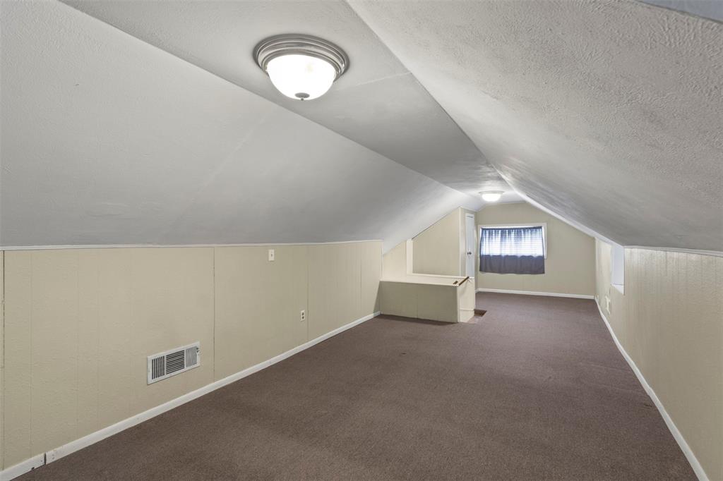 829 West 9th Street Bonham, TX 75418 - Photo 24 of 30 Carpeted room with sloped ceilings and light beige paneling