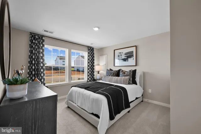 a large bedroom with a large bed and a potted plant