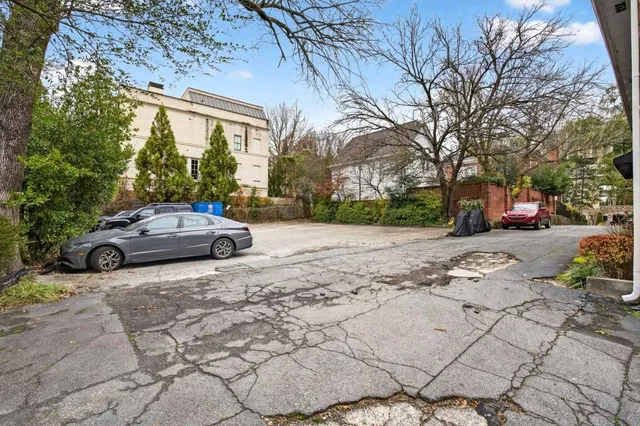 a view of a yard with a car parked in front of it