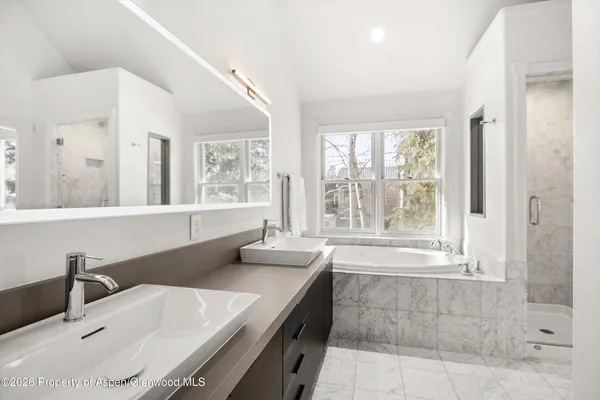 a bathroom with a granite countertop sink and a bathtub