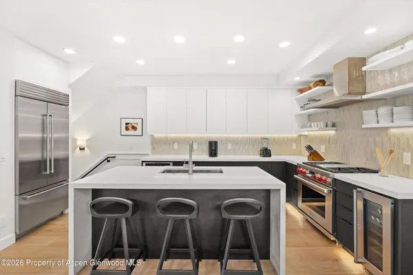 a kitchen with stainless steel appliances granite countertop a stove a sink and a refrigerator