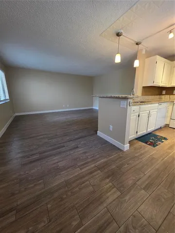 a view of a kitchen with a sink and wooden floor