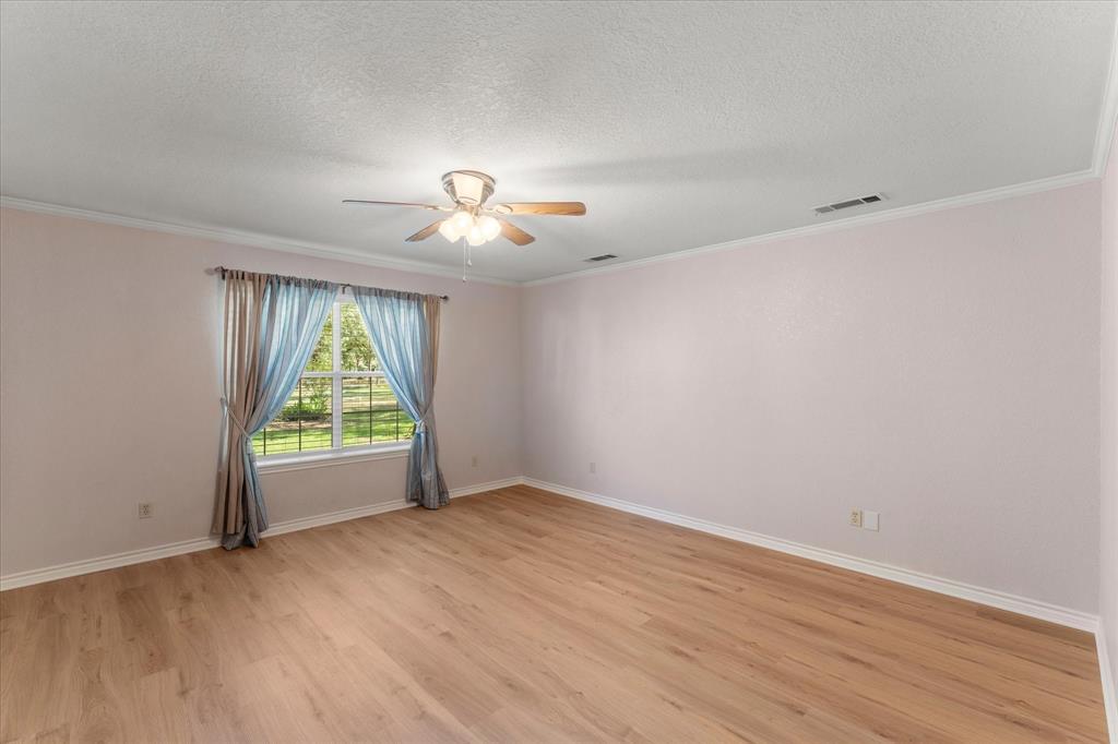 116 Meadowood Road Enchanted Oaks, TX 75156 - Photo 24 of 37 Spacious room featuring wood-finish flooring, a ceiling fan with integrated lighting, and a window providing natural light