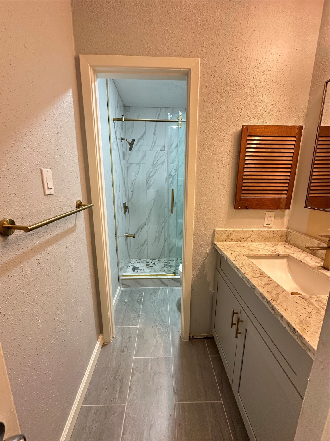 9631 Stockwell Street Houston, TX 77083 - Photo 20 of 23 a bathroom with a granite countertop sink a mirror and a shower