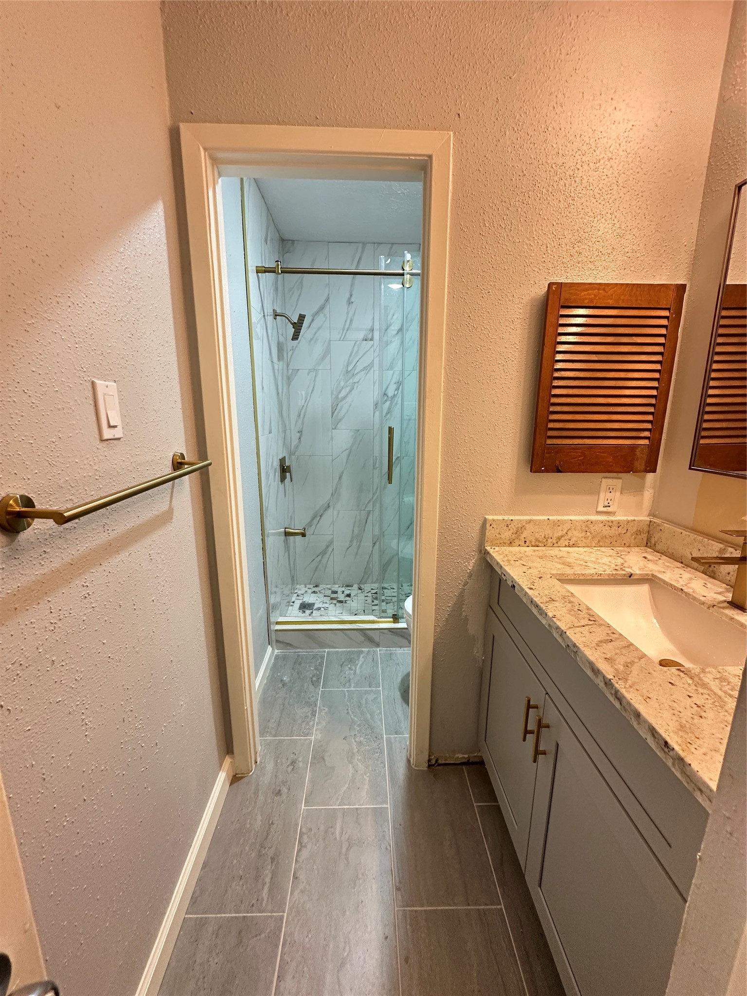 9631 Stockwell Street Houston, TX 77083 - Photo 20 of 23 a bathroom with a granite countertop sink a mirror and a shower