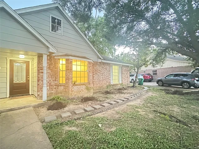 a view of a house with a patio and a yard