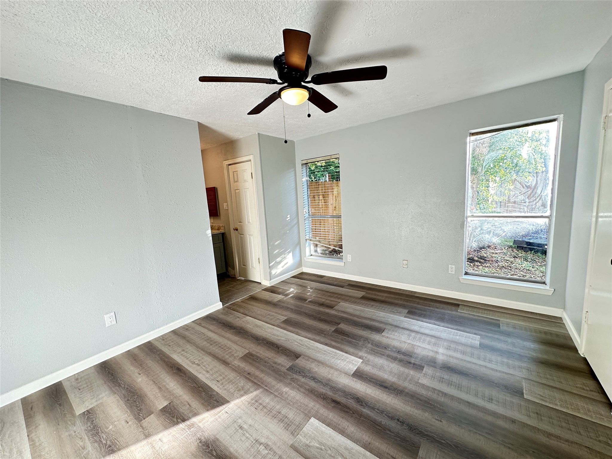 9631 Stockwell Street Houston, TX 77083 - Photo 5 of 23 a view of empty room with wooden floor and fan