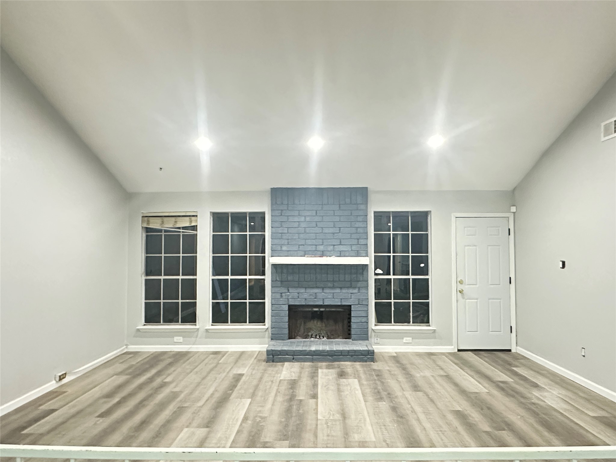 9631 Stockwell Street Houston, TX 77083 - Photo 8 of 23 an empty room with windows and fireplace
