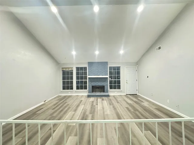an empty room with wooden floor and fireplace