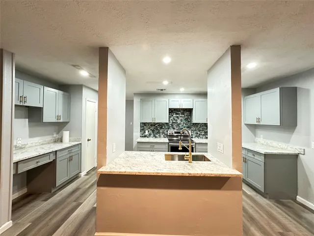 a large kitchen with kitchen island a sink stainless steel appliances and cabinets