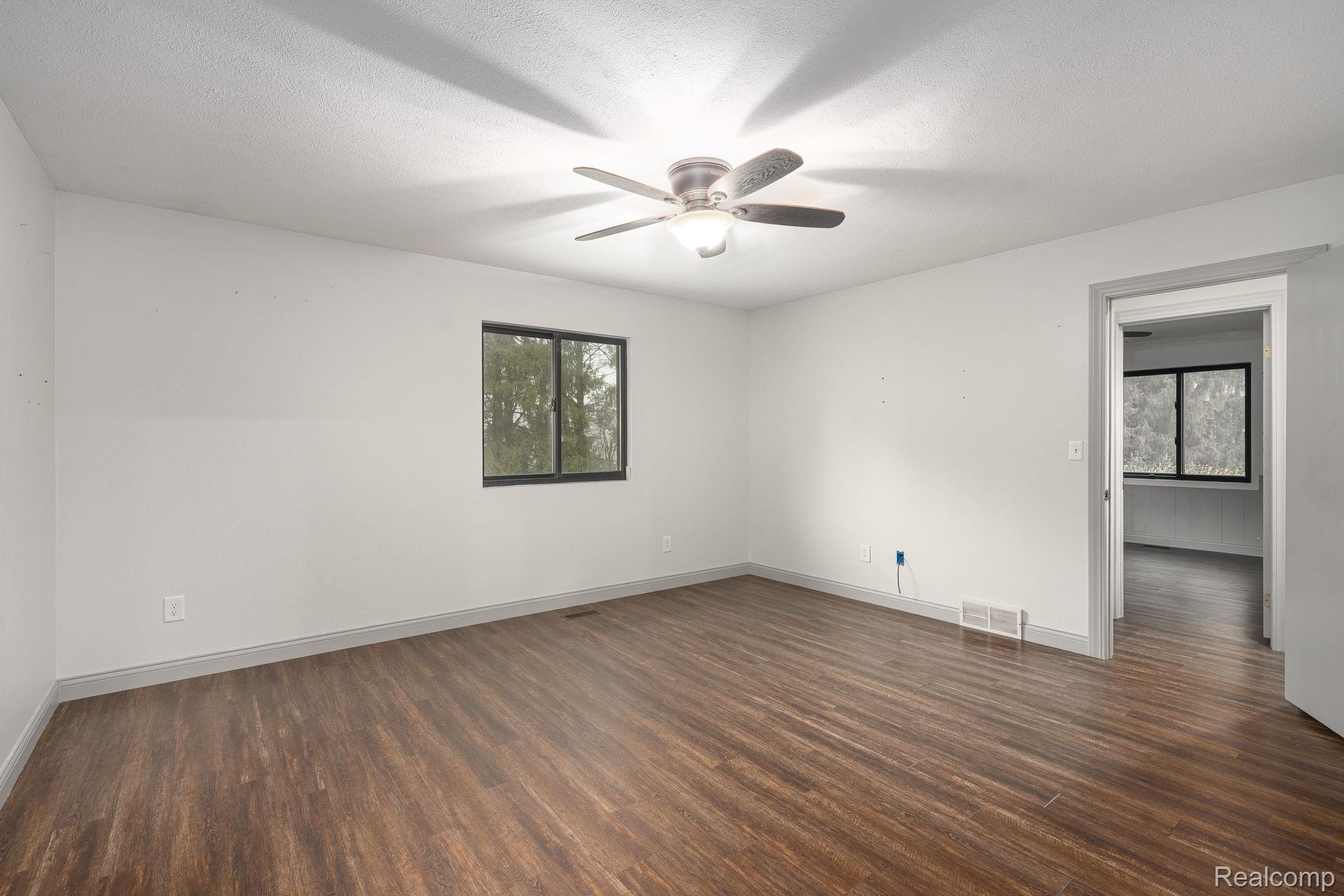 6803 Napoleon Road Jackson, MI 49201 - Photo 34 of 59 Unfurnished room featuring dark wood-style floors and ceiling fan