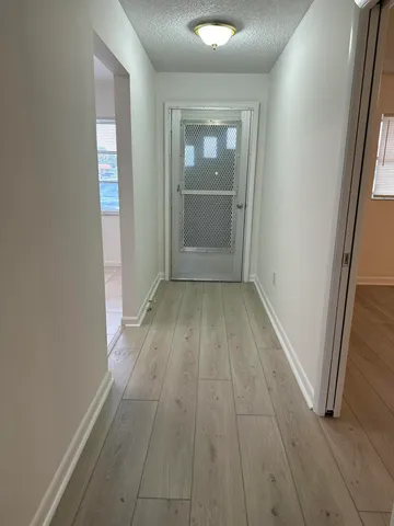 an empty room with wooden floor and mirror