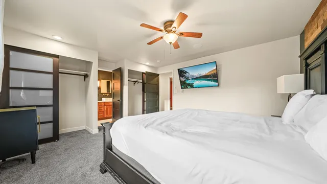 a bed room with a bed and a ceiling fan