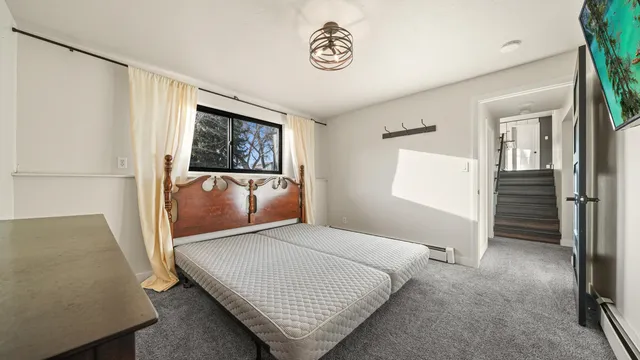 a bedroom with a bed and painting on the wall