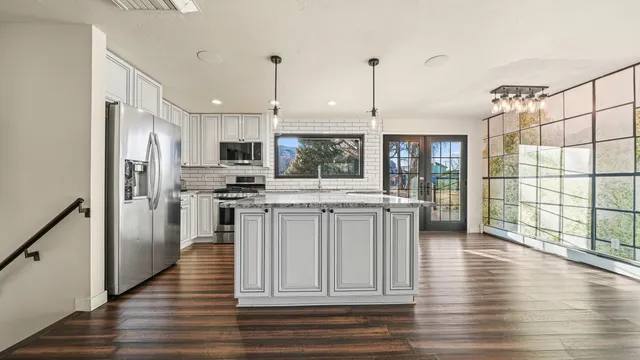 a kitchen with kitchen island granite countertop a stove a sink and a refrigerator