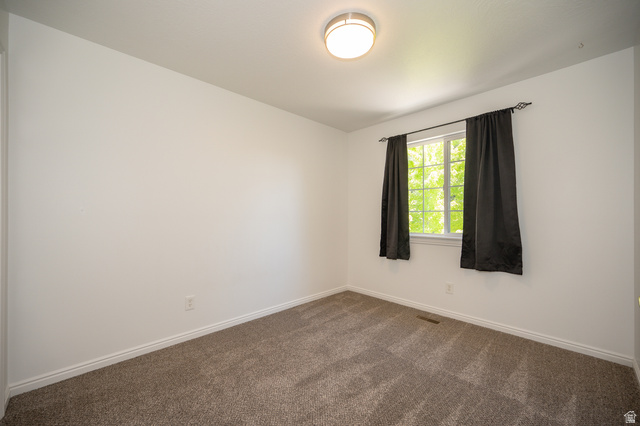 1799 West 1110th Street North Provo, UT 84604 - Photo 20 of 24 White interior walls with a single window featuring black curtains and white trim