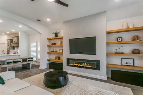 a living room with furniture a flat screen tv and a fireplace