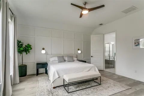 a spacious bedroom with a bed and a potted plant