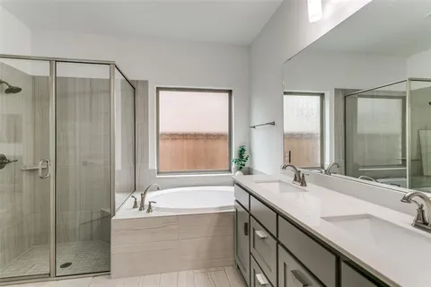 a bathroom with a tub sink and mirror