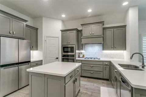 a kitchen with a sink appliances and cabinets