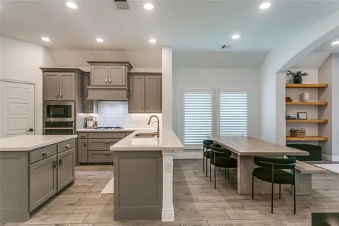 a kitchen with stainless steel appliances granite countertop a sink and a stove