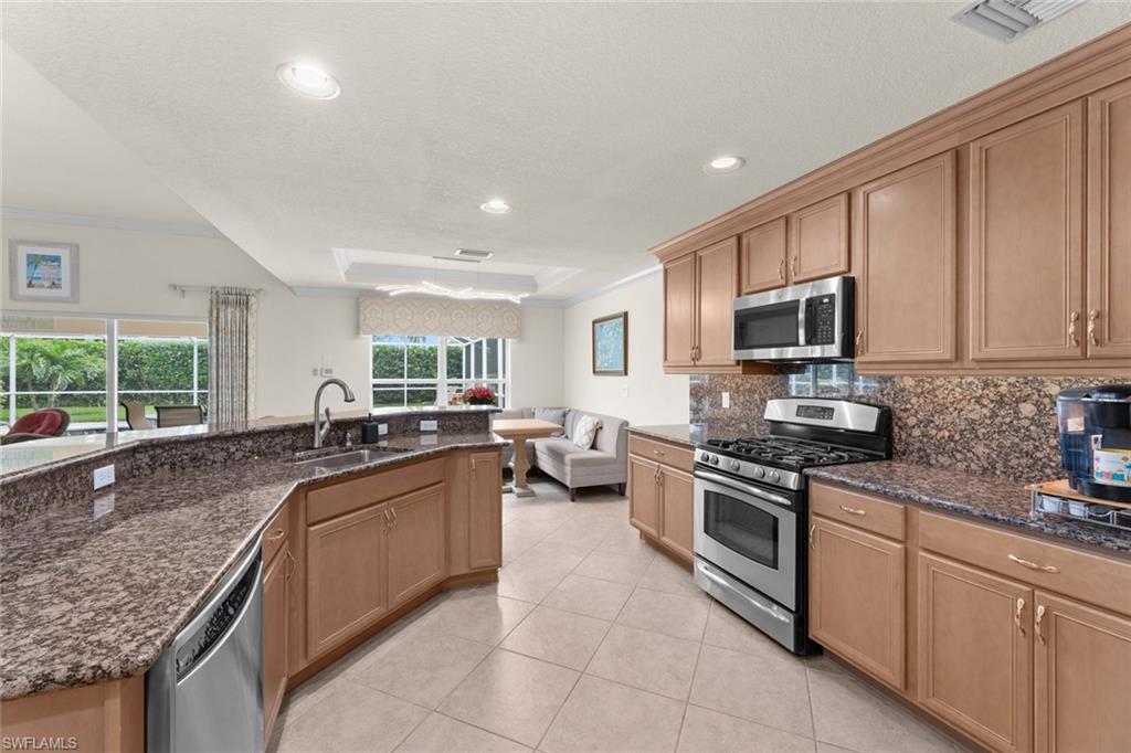 19724 Villa Rosa Loop Estero, FL 33967 - Photo 13 of 50 a kitchen with sink a stove and cabinets