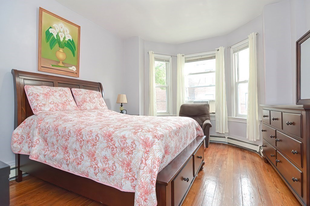 110 Everett Street Boston, MA 02128 - Photo 15 of 41 a bedroom with a bed and a flat tv screen on dresser