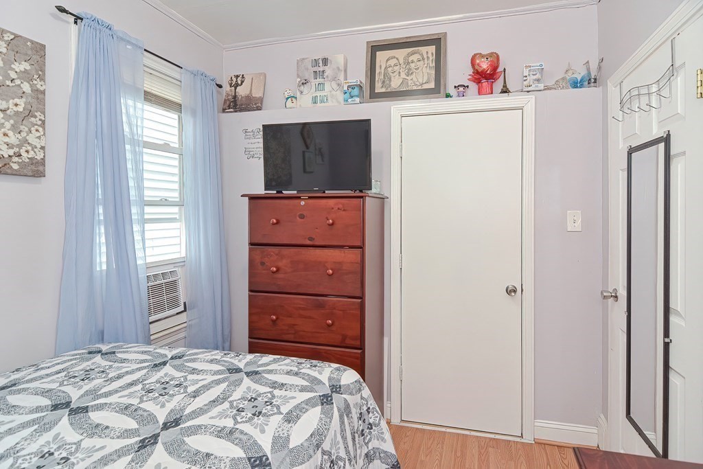 110 Everett Street Boston, MA 02128 - Photo 19 of 41 a bedroom with a refrigerator and a flat screen tv