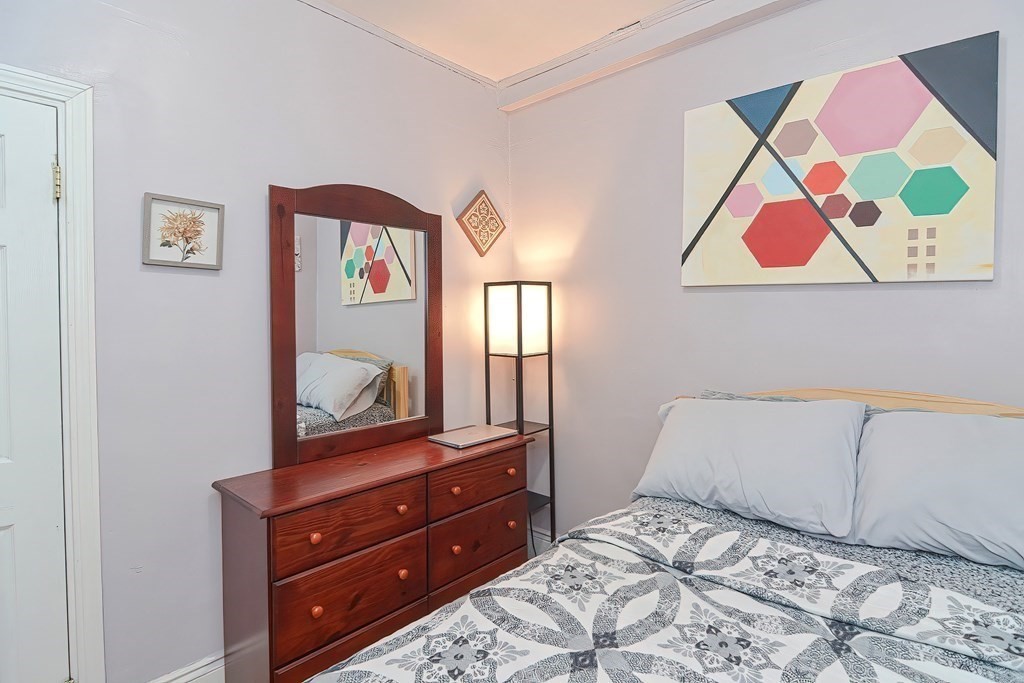 110 Everett Street Boston, MA 02128 - Photo 20 of 41 a bedroom with a bed and a mirror on dresser