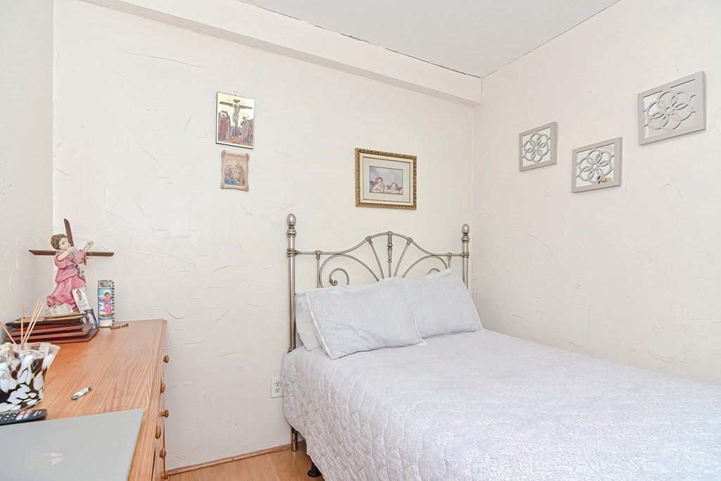 110 Everett Street Boston, MA 02128 - Photo 21 of 41 a bedroom with a bed and wooden floor