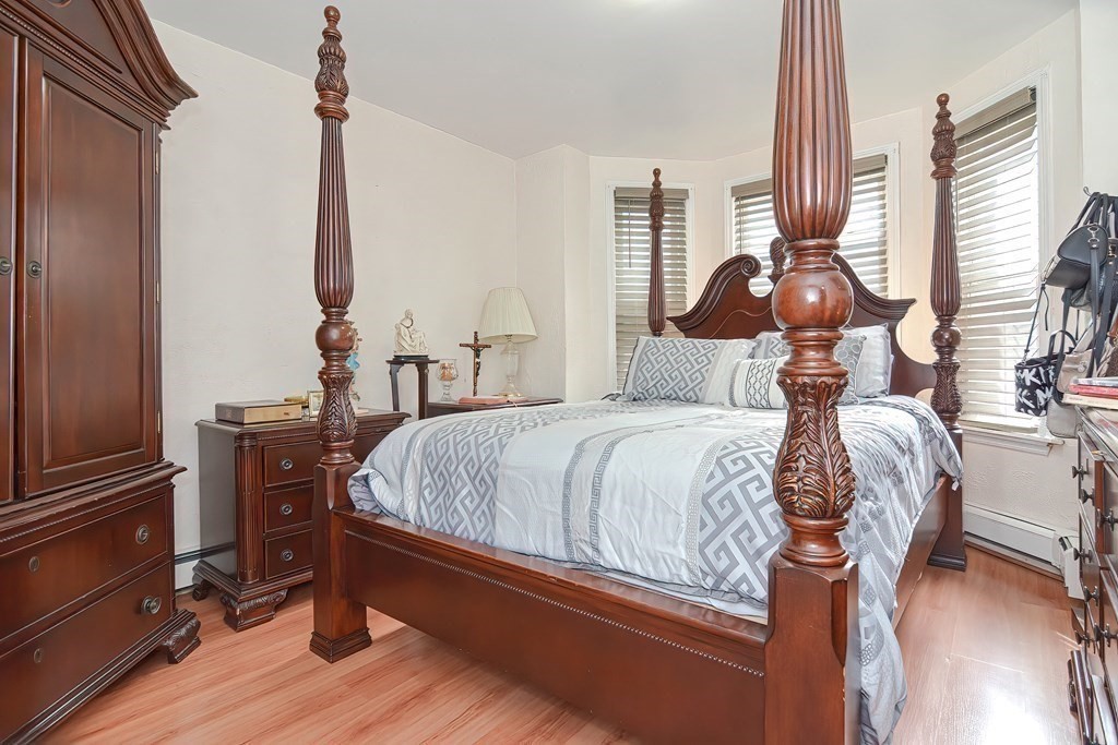 110 Everett Street Boston, MA 02128 - Photo 27 of 41 a bedroom with a bed and wooden floor
