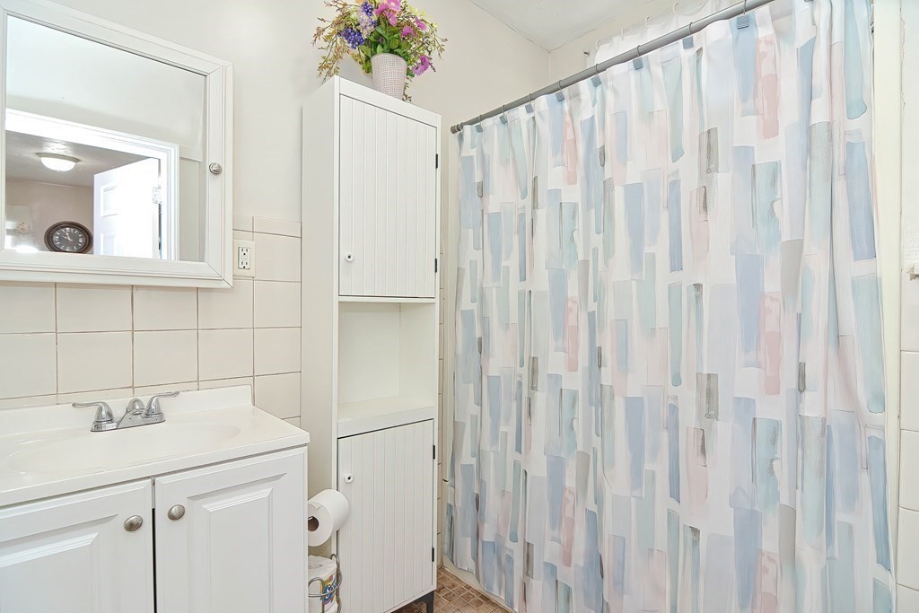110 Everett Street Boston, MA 02128 - Photo 30 of 41 a bathroom with a shower curtain and a sink