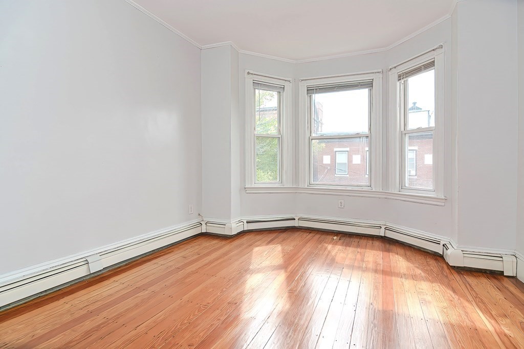 110 Everett Street Boston, MA 02128 - Photo 3 of 41 an empty room with wooden floor and windows