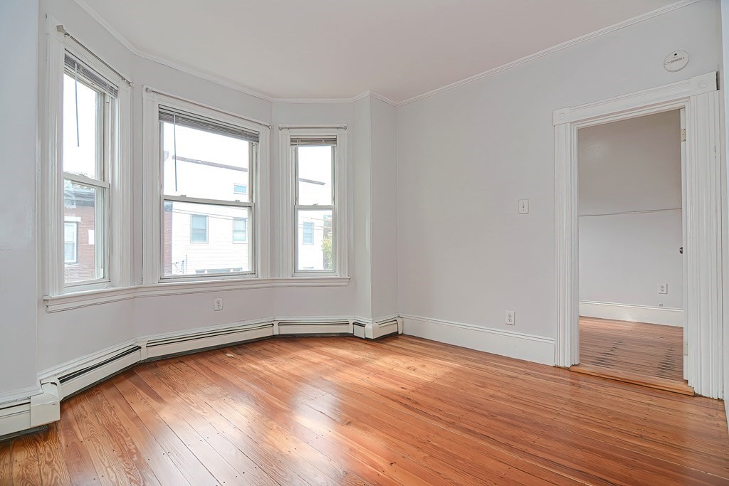 110 Everett Street Boston, MA 02128 - Photo 4 of 41 an empty room with wooden floor and windows