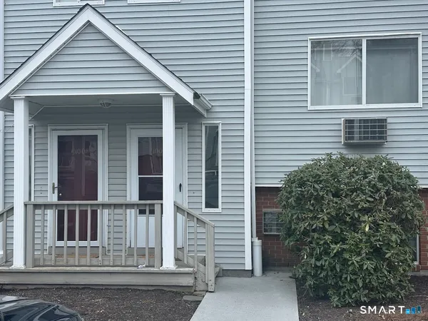 a view of a house with a small window and potted plants