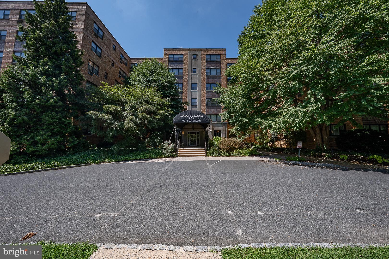 40 Old Lancaster Road, Unit 512 Merion Station, PA 19066 - Photo 60 of 60 a brick building with a small yard and large trees
