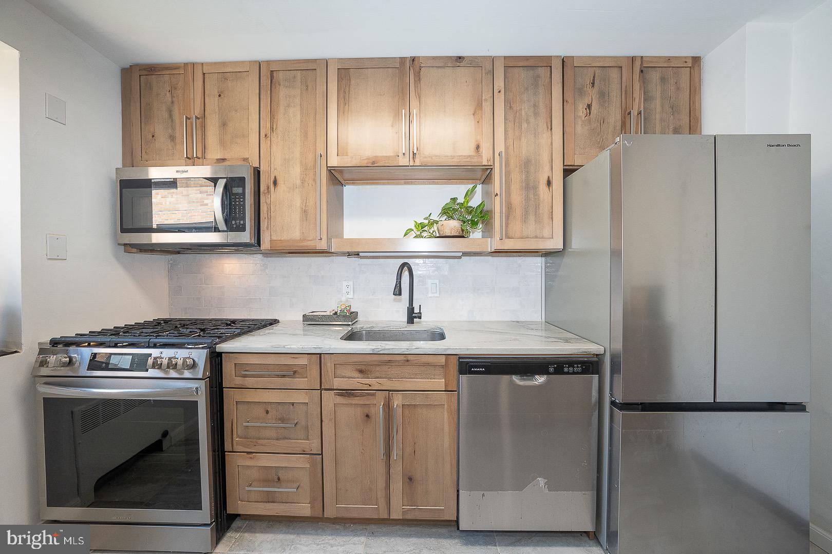 40 Old Lancaster Road, Unit 512 Merion Station, PA 19066 - Photo 10 of 60 a kitchen with stainless steel appliances granite countertop a stove a refrigerator and a sink