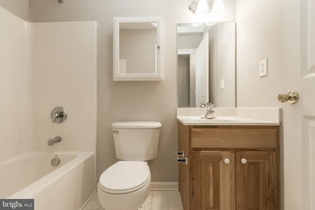 a bathroom with a toilet a sink a mirror a bathtub and vanity