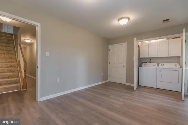 a view of a room with wooden floor and electronic appliances