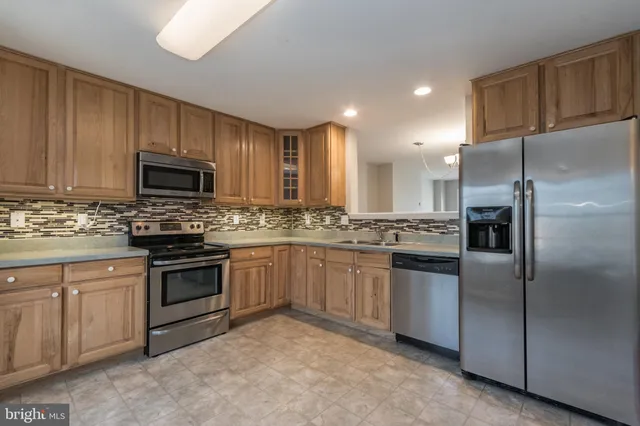 a kitchen with stainless steel appliances granite countertop a refrigerator stove a sink and dishwasher