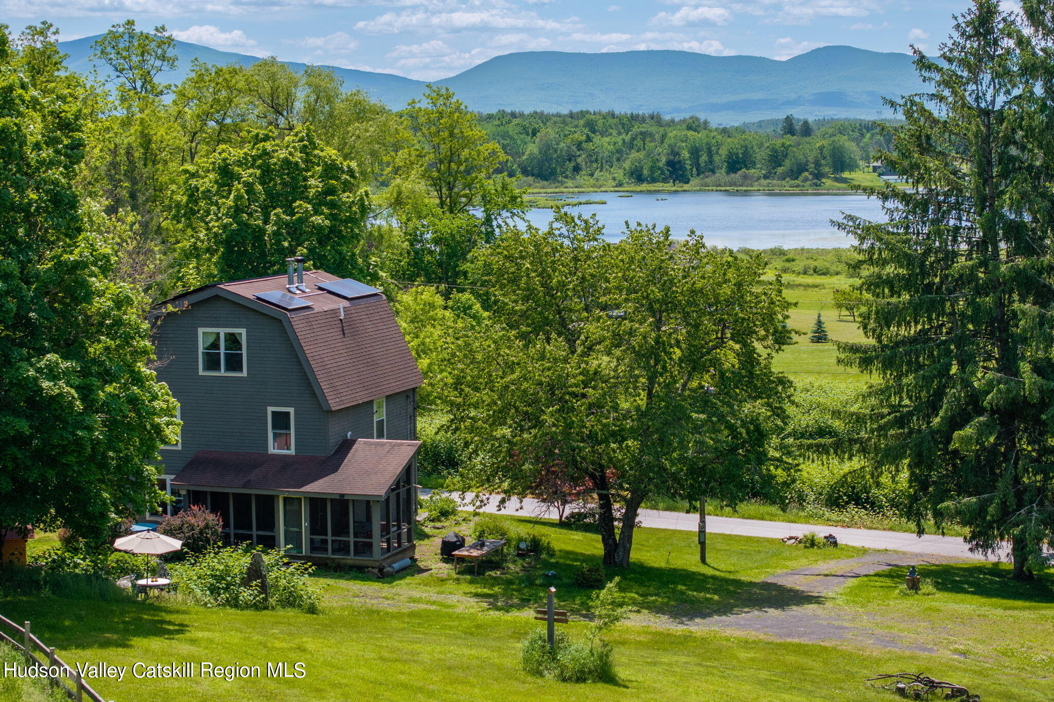 a front view of a house with a yard and lake view