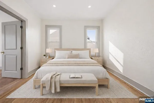 a bedroom with a bed and wooden floor