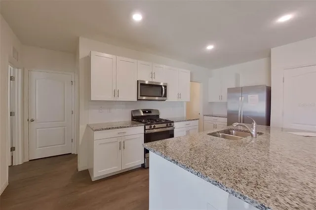 a kitchen with granite countertop sink and window