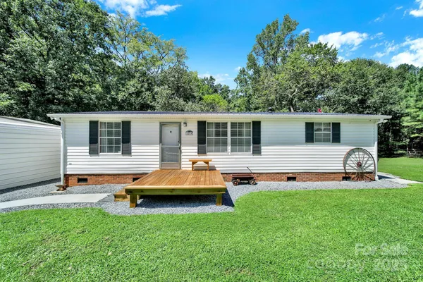 a backyard of a house with table and chairs a barbeque and wooden fence