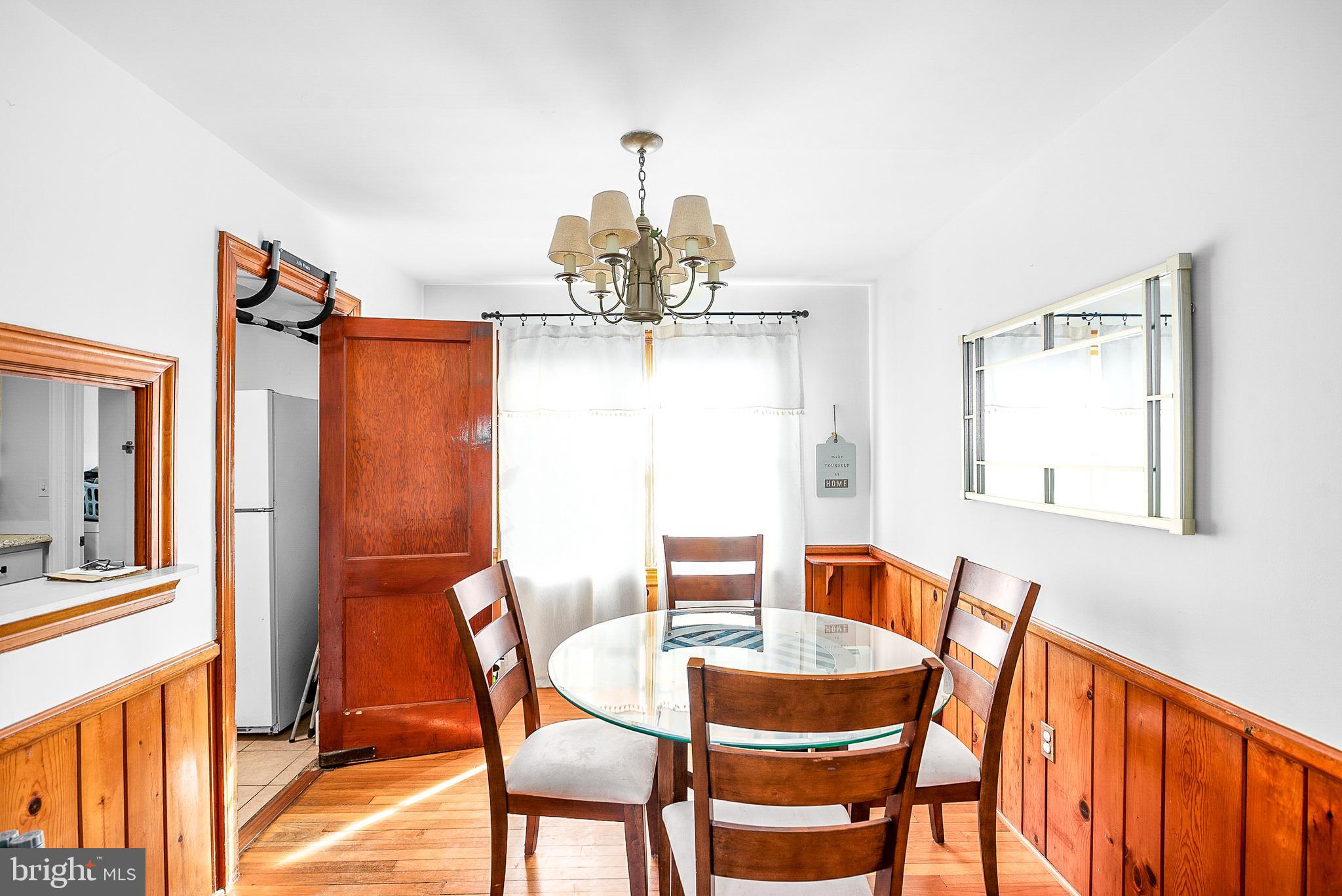 29510 Hawkes Hill Road Easton, MD 21601 - Photo 4 of 32 a dining room with furniture a chandelier and wooden floor