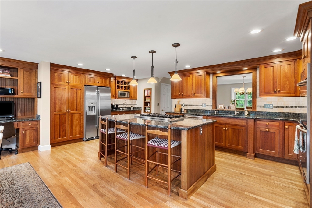 58 High Ridge Road Boxford, MA 01921 - Photo 13 of 40 a open kitchen with stainless steel appliances granite countertop a stove top oven a sink dishwasher a dining table and chairs with wooden floor