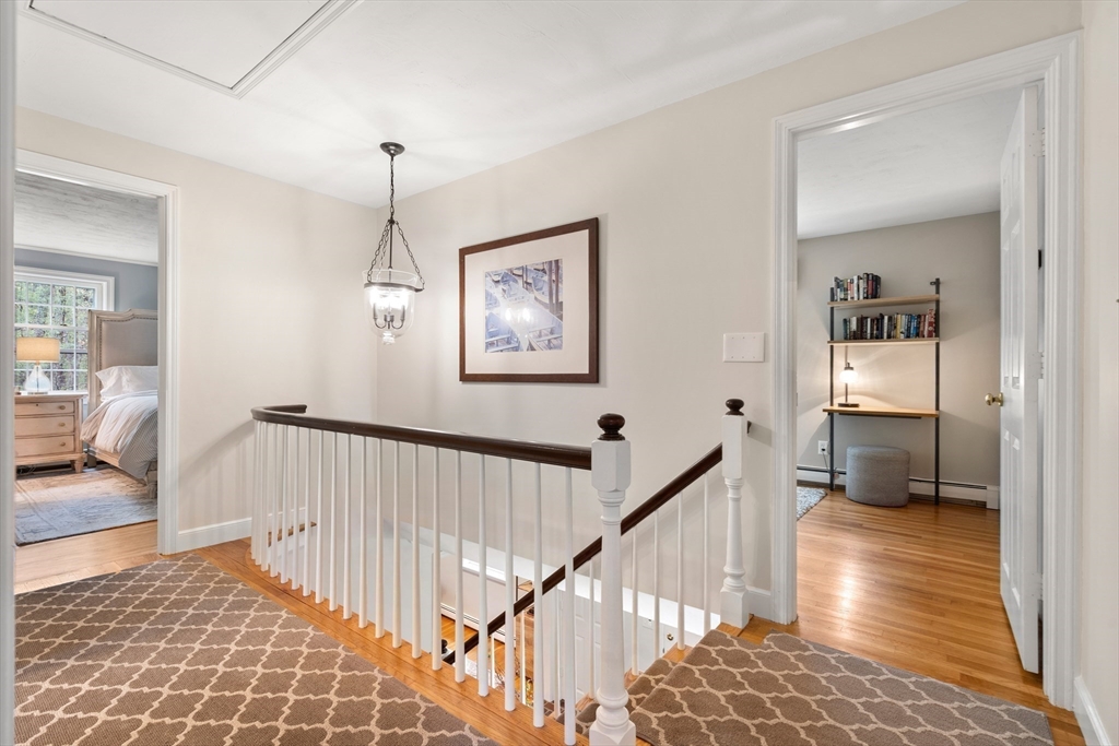 58 High Ridge Road Boxford, MA 01921 - Photo 24 of 40 a view of a hallway to a livingroom with wooden floor and a bathroom