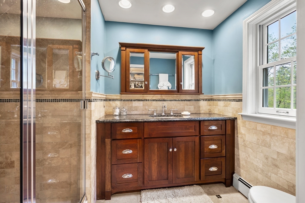 58 High Ridge Road Boxford, MA 01921 - Photo 29 of 40 a bathroom with a granite countertop sink a mirror and a shower