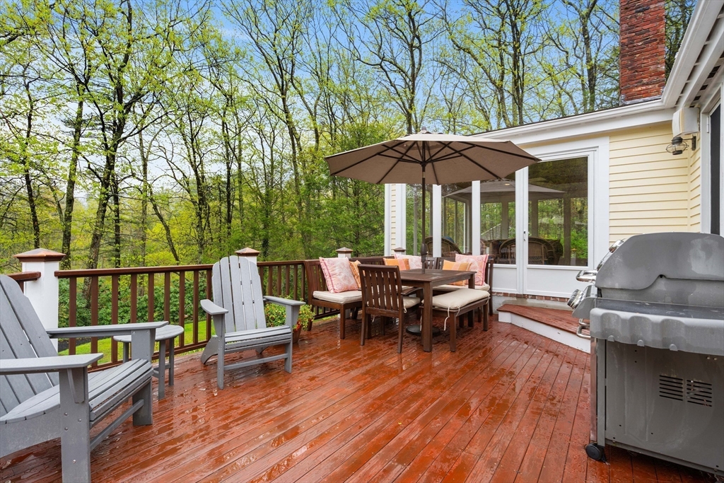 58 High Ridge Road Boxford, MA 01921 - Photo 34 of 40 a view of a patio with table and chairs under an umbrella with wooden floor