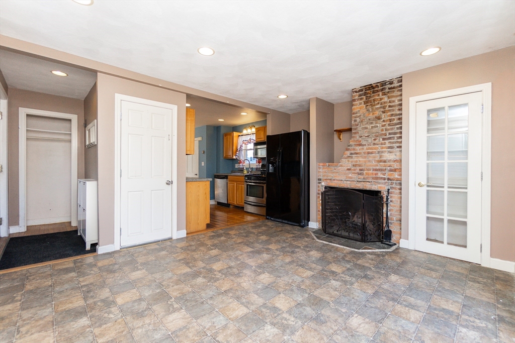 86 Flint Street Salem, MA 01970 - Photo 11 of 30 a view of a kitchen with a sink and a fireplace